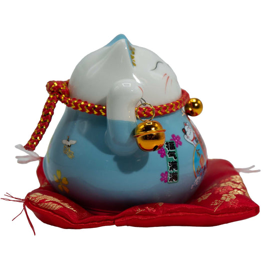 Gato de la suerte de cerámica con la mano que se mueve  - Azul sobre cojín